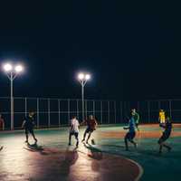 People playing soccer under the streetlamps