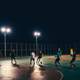 People playing soccer under the streetlamps