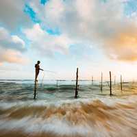 Time-Lapse landscape with fisherman under clouds and sky in Hikkaduwa, Sri Lanka
