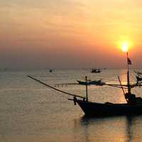 Boats in the ocean at sunset in Thailand