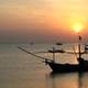 Boats in the ocean at sunset in Thailand