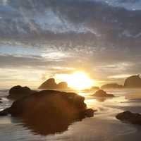 Sunlight setting behind coastal rocks