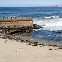 People standing on the Pier looking at the waves on the Ocean