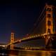 Golden Gate Bridge over the bay at night illuminated in Gold in San Francisco, California