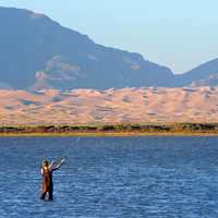 Man fishing while standing in the lake