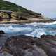 Large Waves crashing on rocks with shoreline landscape