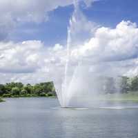 Fountains in the pool under blue sky and clouds at the Chicago Botanical Gardens