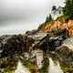 Lighthouse on the rocks on shoreline landscape