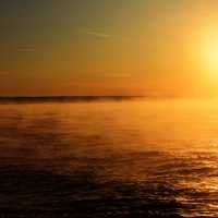 Misty sunset over orange skies at Porcupine Mountains State Park, Michigan