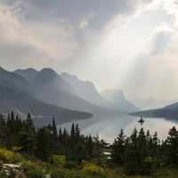 Sunlight from above the clouds over the lake at Glacier National Park, Montana
