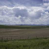 Clouds and farm landscape with town and mountains in Montana