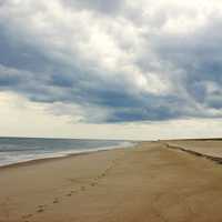 Beach with footsteps in the sand with clouds