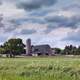 Farmhouse and farm under clouds in North Dakota