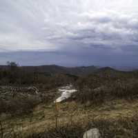 Mountains in the distance in the landscape under rain clouds at Sassafras Mountain