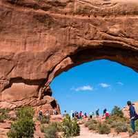 Tourists standing below giant arch