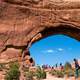 Tourists standing below giant arch