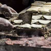 Hands preparing hamburgers and tacos at Taste of Madison