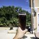 Hand holding a pint of Cherry Berry at New Glarus Brewery