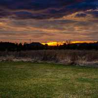 Setting sun under the cloudy sky and landscape at Fonferek Glen, Wisconsin Free Stock Photo