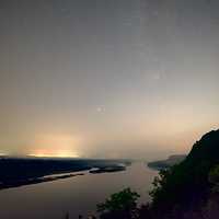 Stars and galaxy above the foggy river