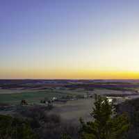 Sunset landscape with farmland and bluff