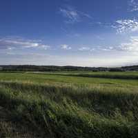 Farmland landscape under blue sky on Sugar River State Trail