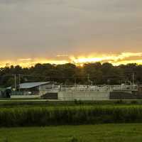 Sun setting above the trees and buildings on the Sugar River State Trail