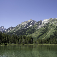 Mountains in the distance across the green lake water