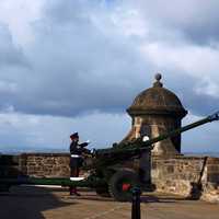 Man shooting large artillery weapon